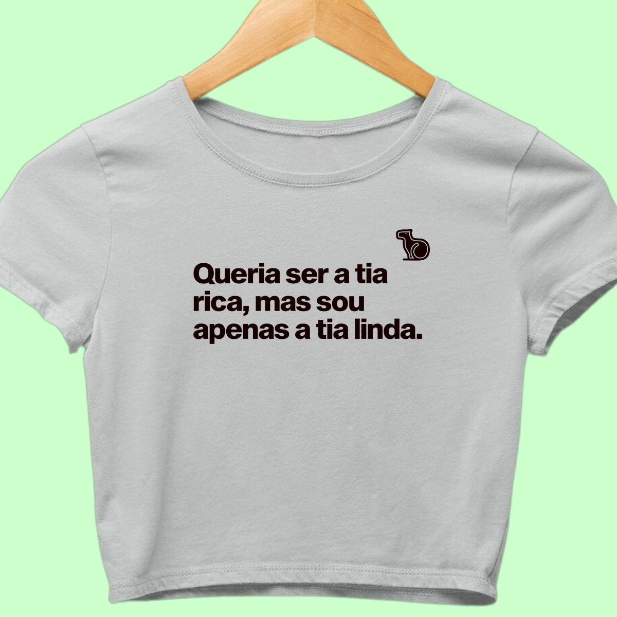 Camiseta cropped com a frase "Queria ser a tia rica, mas sou apenas a tia linda." cinza.