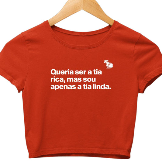 Camiseta cropped com a frase "Queria ser a tia rica, mas sou apenas a tia linda." vermelha.