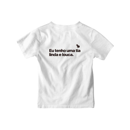 Camiseta infantil com a frase "Eu tenho uma tia linda e louca." na cor branca.